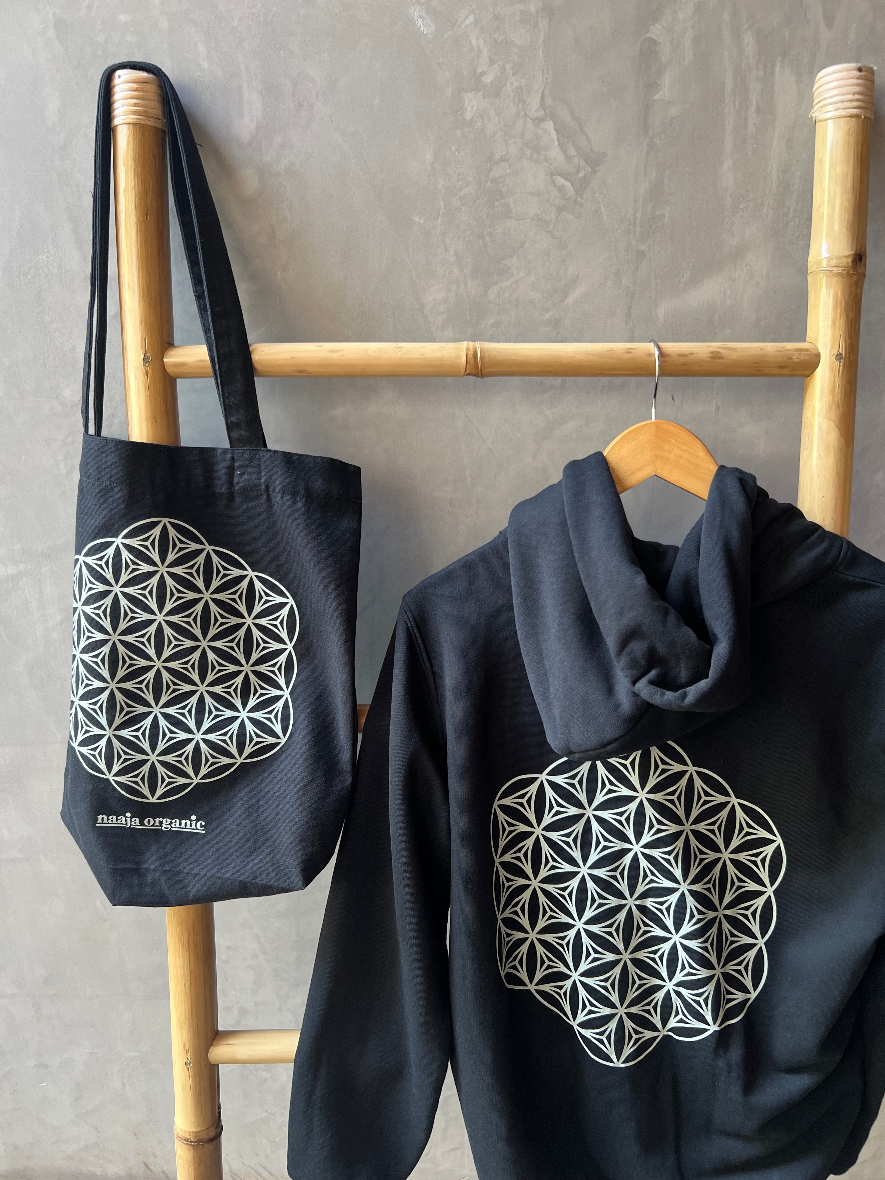 Soft Organic Cotton Zip Hoodie in Jet Black and Dusk with a sacred geometry mandala print, matched with a black recycled cotton tote featuring a matching mandala design. Ethically made for sustainable and eco-friendly living