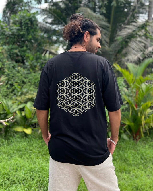 Person wearing a black t-shirt with a geometric design outdoors