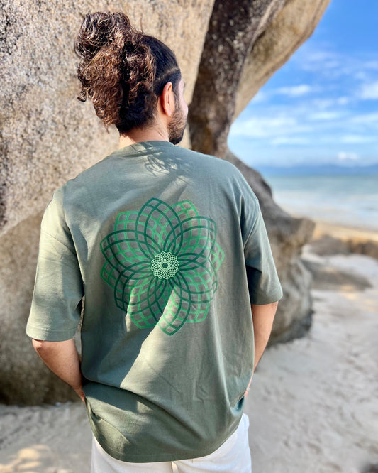 Person wearing a green t-shirt with a geometric design on the beach