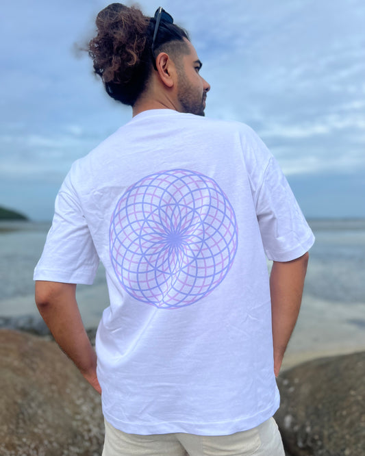 Person wearing a white t-shirt with a geometric design on the beach